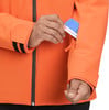 Ein Mann steckt eine Karte in eine Ärmeltasche einer orangefarbenen Jacke.