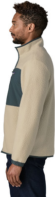 Ein Mann in einer cremefarbenen Fleecejacke mit dunkelgrünem Brustpaneel. Ein Mann in einer cremefarbenen Fleecejacke mit dunkelgrünem Brustpaneel.