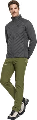 Ein Mann in dunkler Jacke und grüner Hose posiert mit verschränkten Händen. Ein Mann in dunkler Jacke und grüner Hose posiert mit verschränkten Händen.