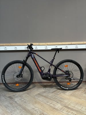 Lila E-Bike mit orangefarbenen Details am Rahmen und an der Gabel. Lila E-Bike mit orangefarbenen Details am Rahmen und an der Gabel.