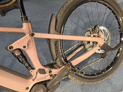 Hinterteil eines rosafarbenen E-Bikes mit RockShox-Dämpfer und Bosch-Motor. Hinterteil eines rosafarbenen E-Bikes mit RockShox-Dämpfer und Bosch-Motor.