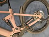 Hinterteil eines rosafarbenen E-Bikes mit RockShox-Dämpfer und Bosch-Motor.