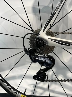 Eine hintere Schaltwerk an einem weißen Rennrad mit schwarzen Speichen. Eine hintere Schaltwerk an einem weißen Rennrad mit schwarzen Speichen.