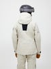 Rückansicht einer Person in einer beigen Skijacke und Hose mit Helm.