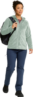Eine Frau in einer grünen Fleecejacke mit Rucksack und blauer Hose. Eine Frau in einer grünen Fleecejacke mit Rucksack und blauer Hose.