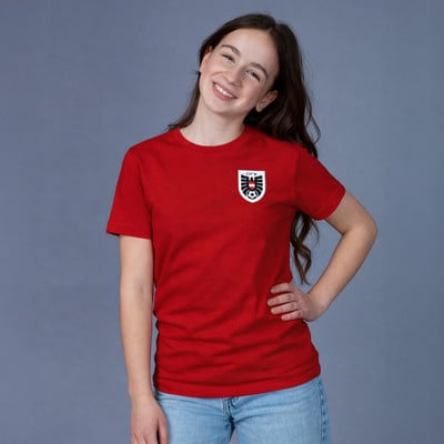 Ein Mädchen in einem roten T-Shirt mit einem Logo und einem Fußball auf der Brust. Ein Mädchen in einem roten T-Shirt mit einem Logo und einem Fußball auf der Brust.