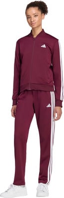 Frau in dunkelrotem Adidas Trainingsanzug mit weißen Streifen und Sneakern.