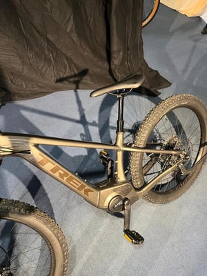Detail eines Trek E-Bikes mit Federung und starkem Rahmen auf blauem Teppich. Detail eines Trek E-Bikes mit Federung und starkem Rahmen auf blauem Teppich.