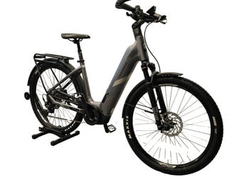 Graues E-Bike mit Federung und Gepäckträger auf weißem Hintergrund.