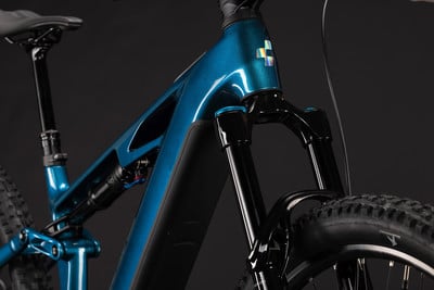 Ein blaues Mountain-E-Bike mit Federung und schwarzem Rahmen. Ein blaues Mountain-E-Bike mit Federung und schwarzem Rahmen.