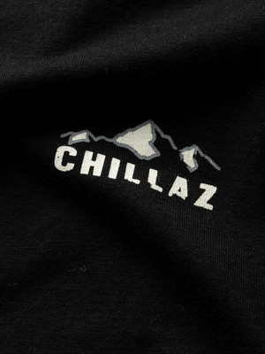 Logo mit Bergen und Schriftzug CHILLAZ auf schwarzem T-Shirt. Logo mit Bergen und Schriftzug CHILLAZ auf schwarzem T-Shirt.