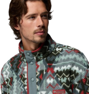Ein Mann in einem Fleece-Pullover mit ethnischem Muster und rotem Kragenrand. Ein Mann in einem Fleece-Pullover mit ethnischem Muster und rotem Kragenrand.