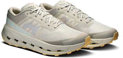 Beige Laufschuhe mit blauer Schrift und gelber Sohle. Beige Laufschuhe mit blauer Schrift und gelber Sohle.