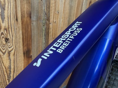 Ein blauer Fahrradrahmen mit weißer Aufschrift Intersport Breitfuss. Ein blauer Fahrradrahmen mit weißer Aufschrift Intersport Breitfuss.