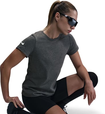 Eine Frau in dunklem Shirt und Shorts mit Sonnenbrille hockt.