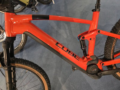 Detail eines orangefarbenen Cube Mountainbikes mit schwarzen Elementen. Detail eines orangefarbenen Cube Mountainbikes mit schwarzen Elementen.