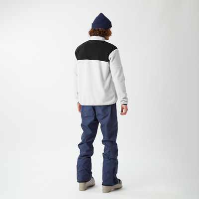 Mann in blauer Mütze und Fleecejacke mit schwarzem Streifen.