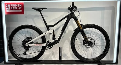 Ein vollgefedertes Mountainbike mit Carbonrahmen und goldenen Fox-Dämpfern. Ein vollgefedertes Mountainbike mit Carbonrahmen und goldenen Fox-Dämpfern.