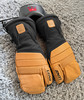 Schwarze und braune Skihandschuhe mit Lenz-Heizung auf Teppich.