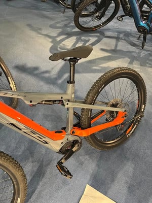 Detail eines Mountain-E-Bikes mit orangefarbenen Akzenten und Dämpfer. Detail eines Mountain-E-Bikes mit orangefarbenen Akzenten und Dämpfer.