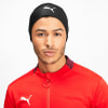 Ein Mann in einer schwarzen Mütze mit Puma-Logo und roter Jacke.
