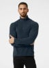 Ein Mann in einem dunkelblauen Fleece-Pullover mit Stehkragen und kurzem Reißverschluss.