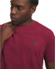 Ein Mann in einem dunkelroten T-Shirt mit Under Armour Logo auf der Brust.