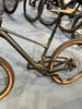 Schwarzes Mountainbike mit braunen Reifen und Federung.