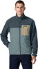 Ein Mann in einer dunkelblauen Fleecejacke mit einer beige Tasche und dunkelblauen Jeans.