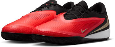 Schwarze und rote Nike-Schuhe mit einem geschwindigkeitsinspirierten Design und goldenen Akzenten.