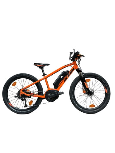 Orange KTM Mountain E-Bike mit schwarzen Rädern und Rahmen.