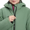 Ein Mädchen schließt eine grüne Jacke mit einem Reißverschluss, Nahaufnahme der Jacke.
