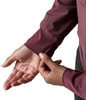Detail einer Hand und eines Ärmels eines dunkelweinroten Kleidungsstücks auf weißem Grund.