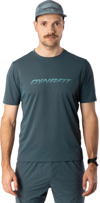 Ein Mann in einem dunkelblauen T-Shirt und einer Kappe mit Dynafit-Logo. Ein Mann in einem dunkelblauen T-Shirt und einer Kappe mit Dynafit-Logo.