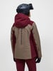 Rückansicht einer Skifahrerin in einer Peak Performance Jacke und einem Salomon Helm.