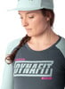 Eine Frau mit einem Zopf trägt ein dunkles T-Shirt mit Dynafit-Logo.