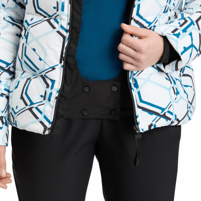 Detail einer Damen-Winterjacke mit geometrischem Muster und schwarzer Hose. Detail einer Damen-Winterjacke mit geometrischem Muster und schwarzer Hose.