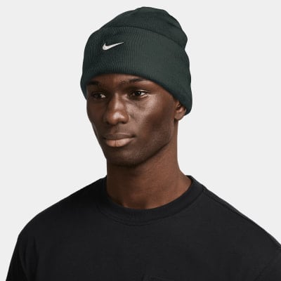 Mann in dunkelgrüner Nike-Mütze mit weißem Logo und schwarzem T-Shirt. Mann in dunkelgrüner Nike-Mütze mit weißem Logo und schwarzem T-Shirt.