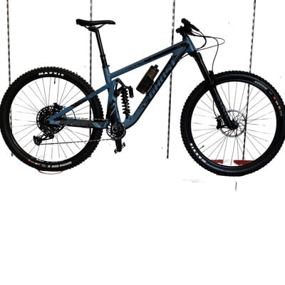 Graues Mountainbike mit Federung und schwarzen Maxxis-Reifen.