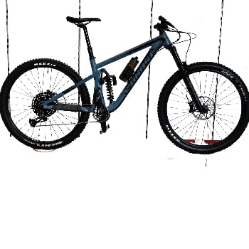 Graues Mountainbike mit Federung und schwarzen Maxxis-Reifen.
