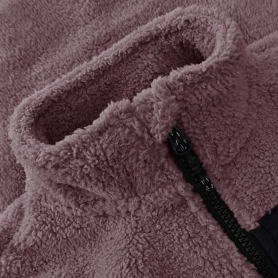Detail aus dem Plüschkragen einer Jacke mit Reißverschluss und schwarzem Detail.