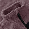Detail aus dem Plüschkragen einer Jacke mit Reißverschluss und schwarzem Detail.