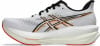 Weiße Laufschuhe mit schwarzen und orangen Streifen und roter Sohle.