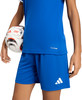Ein Junge hält einen Fußball in einem blauen Adidas-Trikot und Shorts.