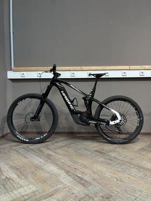 Ein schwarzes Haibike Mountain-E-Bike steht auf einem Holzboden. Ein schwarzes Haibike Mountain-E-Bike steht auf einem Holzboden.
