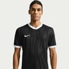 Ein Mann in einem schwarzen Fußballtrikot mit weißem Kragen und Nike-Logo.