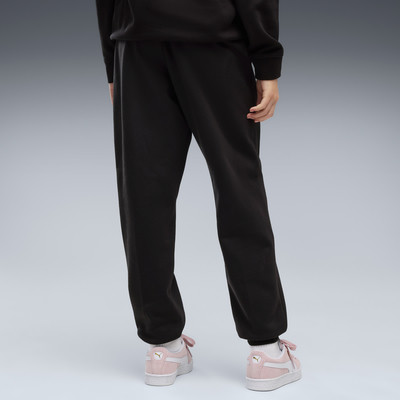 Rückansicht einer Person in schwarzer Jogginghose und rosa Turnschuhen. Rückansicht einer Person in schwarzer Jogginghose und rosa Turnschuhen.