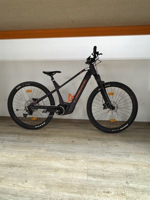 Ein schwarzes Lapierre E-Bike mit orangefarbenen Details auf Holzboden. Ein schwarzes Lapierre E-Bike mit orangefarbenen Details auf Holzboden.