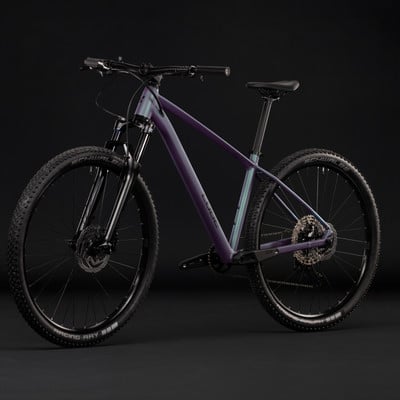 Lila Mountainbike mit Federung und schwarzen Rädern vor dunklem Hintergrund. Lila Mountainbike mit Federung und schwarzen Rädern vor dunklem Hintergrund.