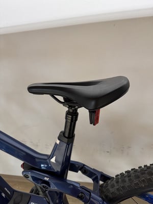 Sattel eines dunkelblauen Mountainbikes mit rotem Reflektor. Sattel eines dunkelblauen Mountainbikes mit rotem Reflektor.